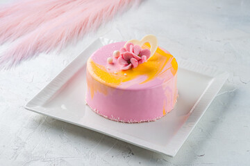 Dessert pink mousse cake decorated with flowers and chocolate heart.