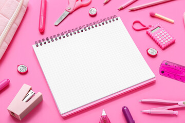 Notebook with different stationery supplies on pink background