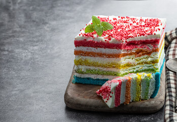 Multicolored rainbow cake on gray background