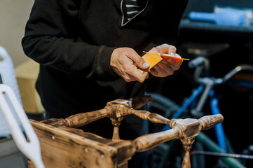 Male professional worker carpenter, woodworker improves with plastic putty putty, cement a wooden...