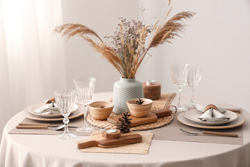 Elegant table setting with dried flowers, pampas grass and pine cones