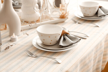 Elegant table setting with folded napkins, bowls and cutlery