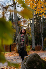 Fototapeta premium man in a skirt walking on an autumn street. people breaking the rules concept