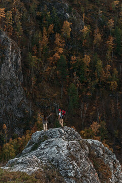 Traveling with children. A couple in love with a child in the mountains. A traveling couple in hiking gear in the mountains. A traveling family. Travelers on the background of mountains. Copy space