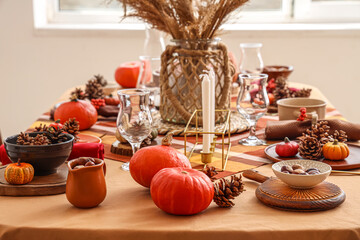 Autumn table setting with pumpkins, pampas grass and pine cones, closeup