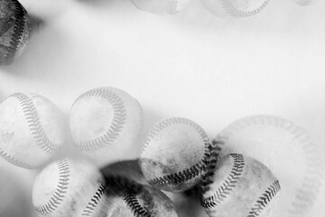 Old baseballs balls as artistic multiple exposure in black and white with copy space on background.