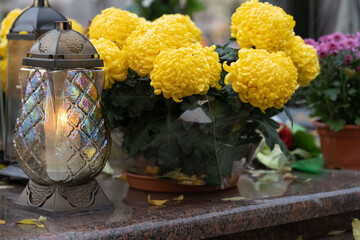 Lantern and flowers on the grave on All Saints' Day