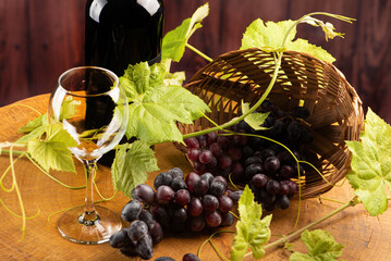 Grapes and wine, basket with beautiful grapes and bottle of red wine, on rustic wood, selective...