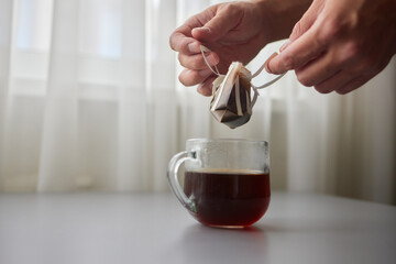 The process of brewing coffee. Water is poured into a drip coffee bag in a mug. Trends in brewing...