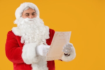 Santa Claus reading letter on yellow background