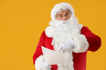 Santa Claus with letter on yellow background