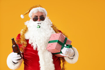 Cool Santa Claus with beer and Christmas gift on yellow background