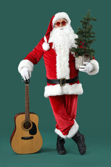 Cool Santa Claus with Christmas tree and guitar on green background