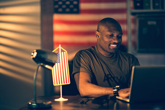 American soldier using a laptop while deployed in an army base