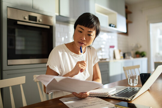 Concerned woman doing home financials in the kitchen