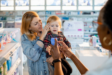 Worried Mother with Toddler Receiving Medicine at Pharmacy