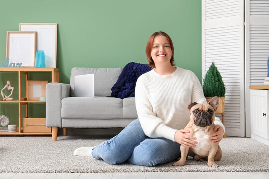 Young Woman With Cute Dog Sitting On Floor At Home