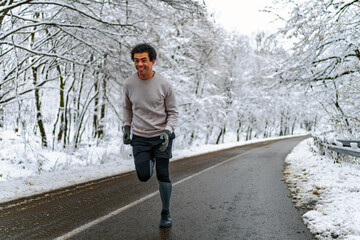 Man looking at his phone and sending text massages, there's snow covered scenery in the background