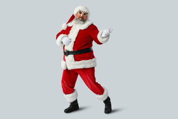 Funny Santa Claus dancing on grey background