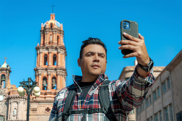 Plus size man tourist taking a selfie in San Luis Potosi downtown in Mexico