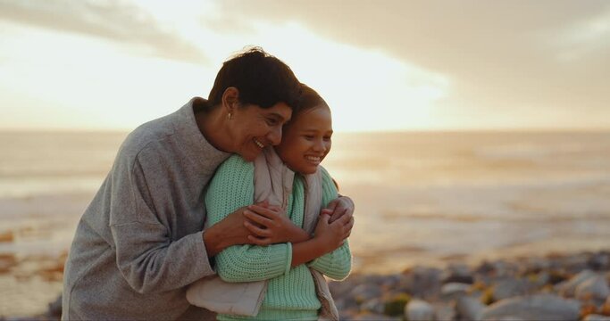 Senior grandmother, girl and hug at beach, smile and love with generations, laugh and vacation in sunset. Happy family, grandma and young kid with care, bonding and relax outdoor for holiday by ocean