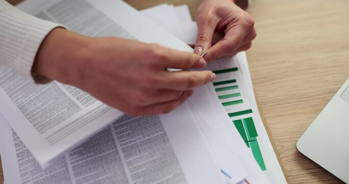 Closeup of woman hands placing paperclip on document