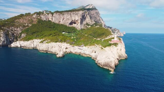 Lighthouse and Beach of Capri in summer season. View from a moving drone