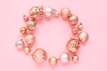 Frame made of Christmas balls on pink background