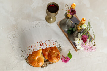 Challah bread, shabbat wine and candles on light background. Traditional Jewish Shabbat ritual....