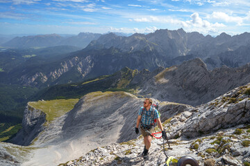 Ein Wanderer kletter über einen Klettersteig auf die Alpsitze in den Bayerischen Alpen.