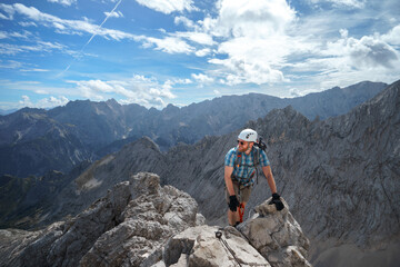 Ein Wanderer kletter über einen Klettersteig auf die Alpsitze in den Bayerischen Alpen.