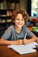 A smiling boy doing homework at home