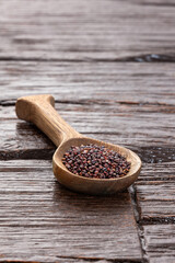 Brown organic quinoa seeds in the spoon - Chenopodium quinoa​