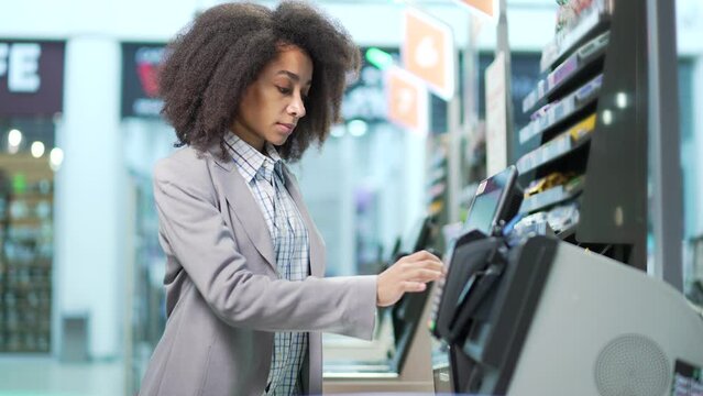 Female shopper using a self-service cashier checkout in a supermarket. Customer scanning produce items using at grocery store self serve cash register. cashier terminal woman pay for products online