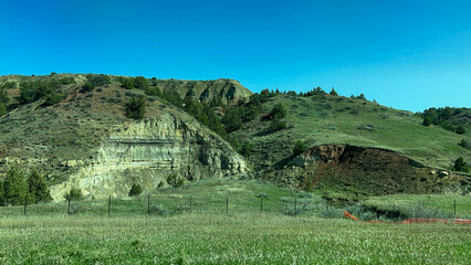Driving through the badlands hills and mountains in Theodore Roosevelt National Park in North...