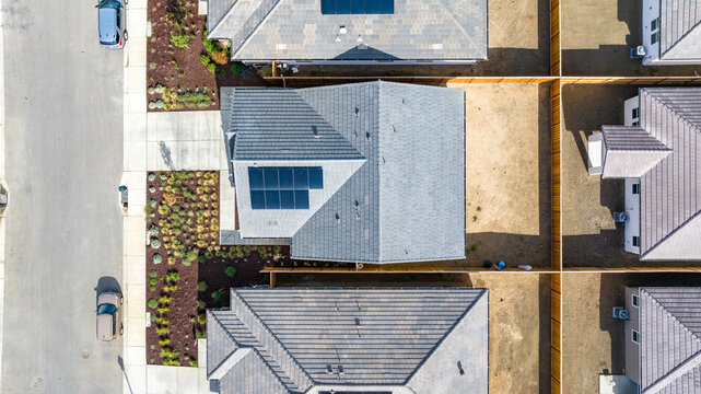 Top Down view of a house with a solar panel on it and a empty backyard