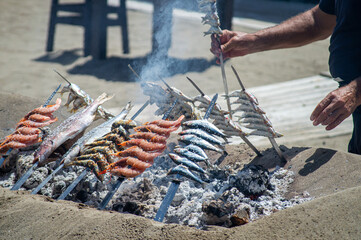 Traditional seafood cooking  (espetos) is deeply rooted in Malaga's fishing heritage - obrazy, fototapety, plakaty