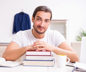 Young male student preparing for exams at home