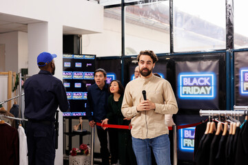 Young man TV reporter covering news real-time, live streaming during Black Friday sales....