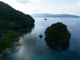 Limestone islands, covered by tropical vegetation, are fringed by coral reefs in Alyui Bay, Raja...