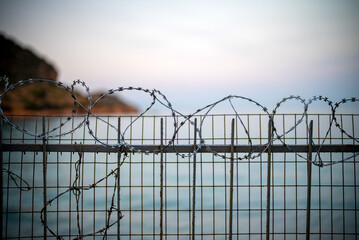 Sea and beach behind barbed wire.