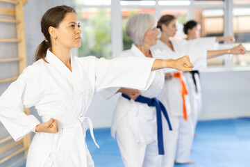 Obraz premium Group of female karatekas practicing karate technique in gym