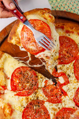 Taking slice of pizza top view close up with melted cheese