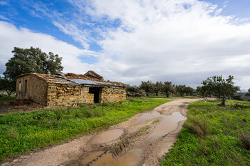 ruins of a brick house with part of the roof intact with an image of a decrepit environment, Malpica do Tejo, Castelo Branco district. November 2023