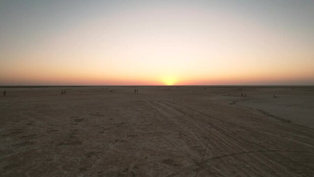 Low drone flight in a salt desert with a sunset. Drone flies forward at low level. General plane