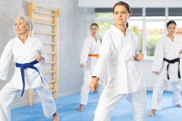 Group of female karatekas practicing karate technique in gym