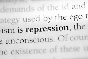Repression, psychological defense mechanism terminology printed in black on white paper close-up....