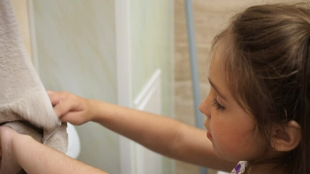 a little cute girl with long dark hair washing in the bathroom. close up hands of children or pupils at preschool Washing hands with soap under the faucet with water. clean and Hygiene concept.