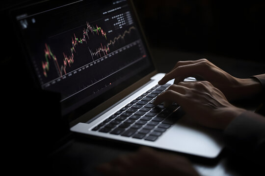 Businessman using laptop analyzing indicators of finance trade with graph showing the ups and downs of the stock market 