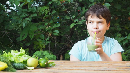 little boy holding disposable plastic glass of strawberry milkshake outdoors. Portrait of happy...